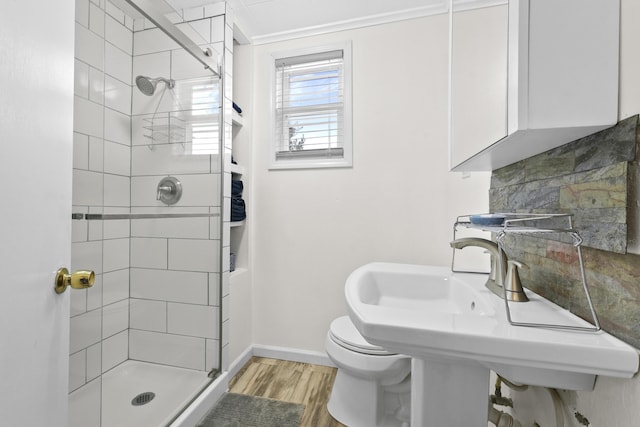 bathroom with decorative backsplash, wood-type flooring, a shower with shower door, and toilet