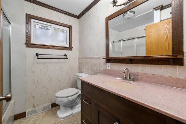 bathroom with tile patterned floors, crown molding, toilet, vanity, and a shower with shower door