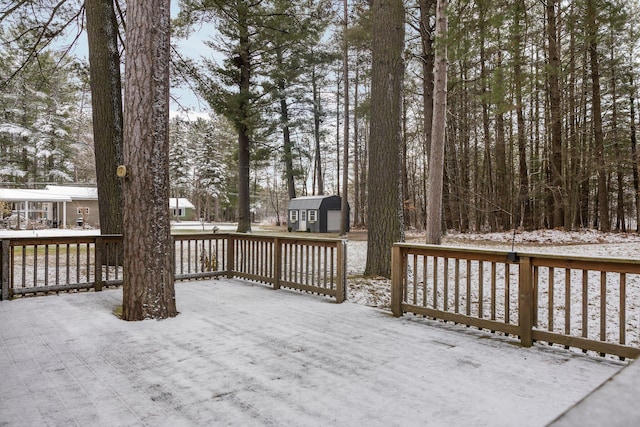 snow covered deck featuring a storage unit