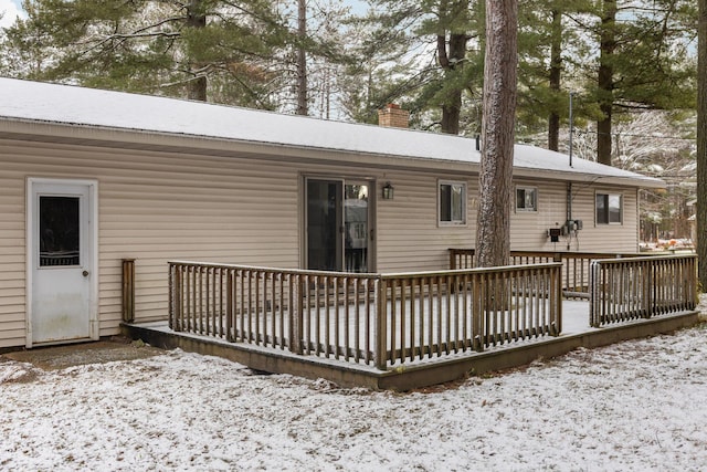 snow covered house featuring a deck