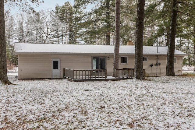 snow covered house featuring a wooden deck