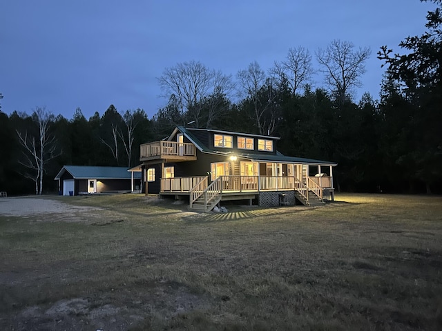 view of front of house featuring a garage, a deck, and an outbuilding