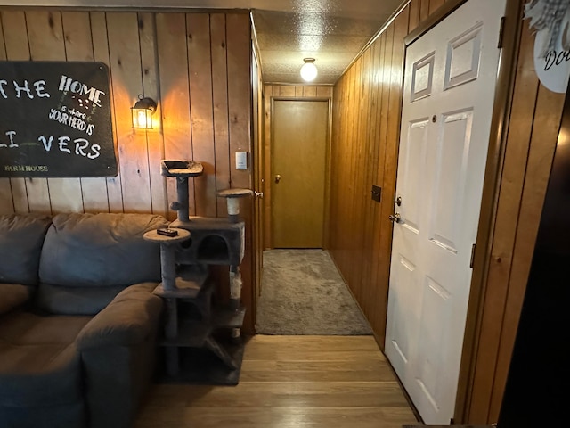 entryway with wooden walls, light hardwood / wood-style flooring, and a textured ceiling