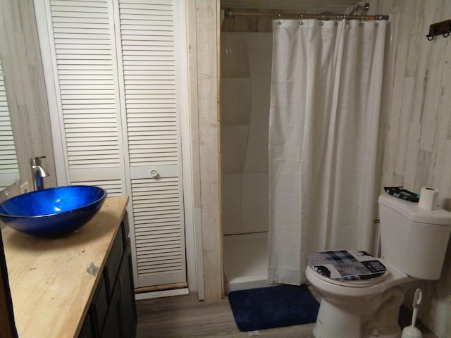 bathroom with hardwood / wood-style flooring, toilet, vanity, and a shower with shower curtain