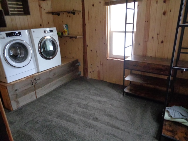 washroom with wooden walls, carpet floors, and washer and dryer