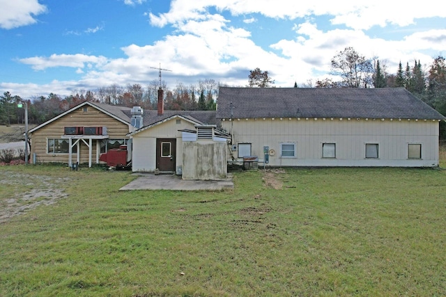 back of house featuring a lawn and a patio