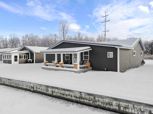 view of snow covered rear of property