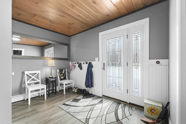 entryway with light hardwood / wood-style floors, crown molding, and wooden ceiling