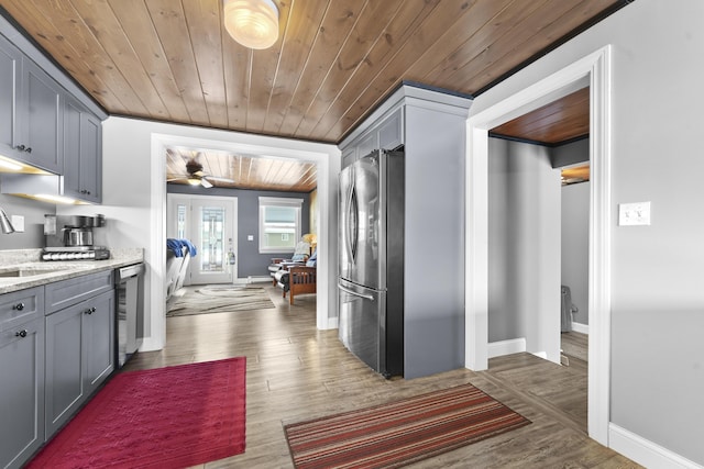 kitchen with light stone counters, gray cabinets, appliances with stainless steel finishes, wood ceiling, and light wood-type flooring