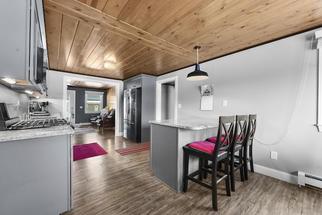 kitchen with gray cabinetry, dark wood-type flooring, and stainless steel refrigerator