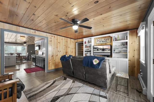 living room featuring ceiling fan, a baseboard radiator, wood walls, hardwood / wood-style floors, and wood ceiling