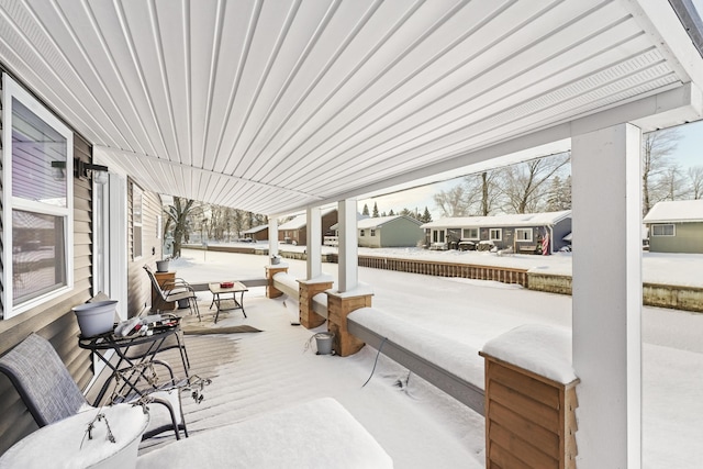 snow covered patio featuring covered porch