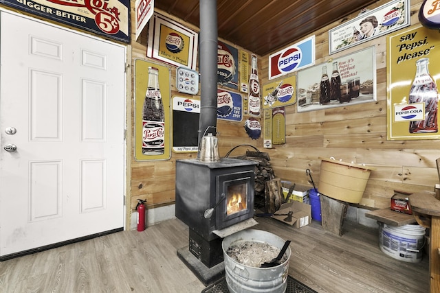 details featuring a wood stove, wood walls, and hardwood / wood-style flooring