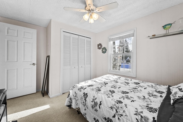 carpeted bedroom with ceiling fan, a textured ceiling, and a closet