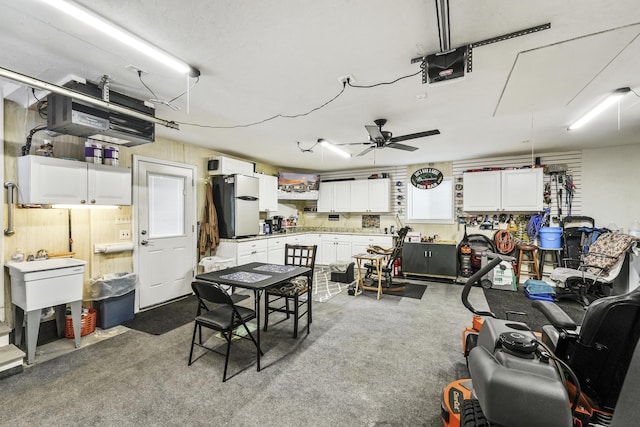 garage featuring a workshop area, ceiling fan, and white refrigerator