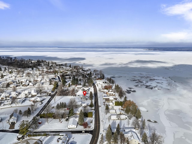 snowy aerial view featuring a water view