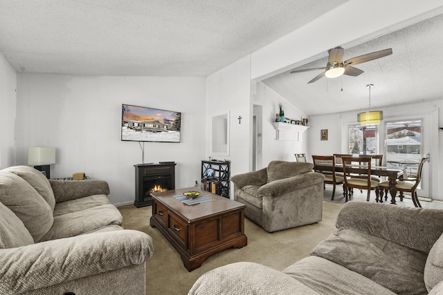 living room with lofted ceiling, light carpet, ceiling fan, a textured ceiling, and a fireplace