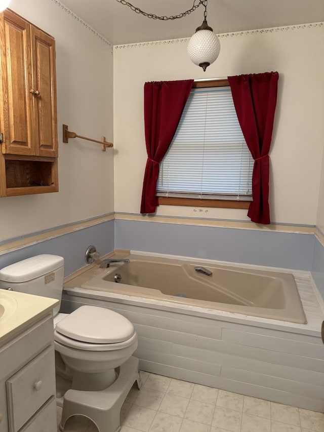 bathroom featuring tile patterned floors, vanity, toilet, and tiled tub