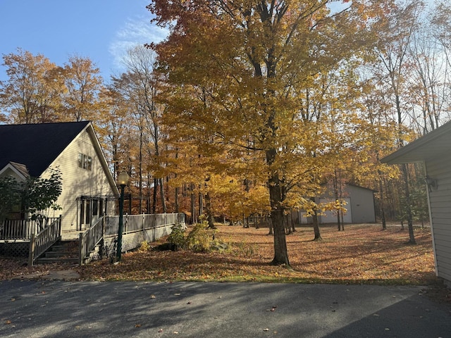 view of property exterior featuring an outbuilding and a deck