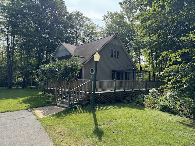 view of side of home featuring a yard and a wooden deck