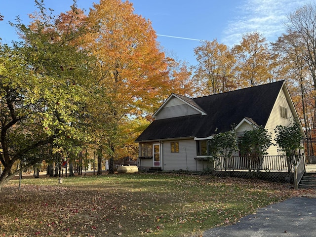 view of property exterior with a lawn and a deck