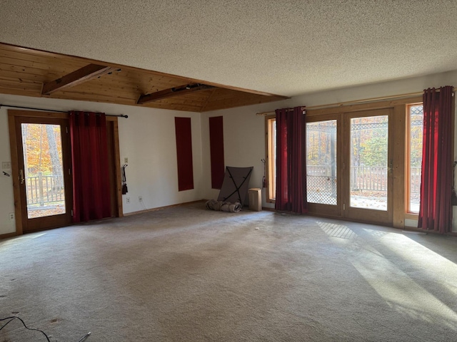 carpeted empty room featuring wooden ceiling and a textured ceiling