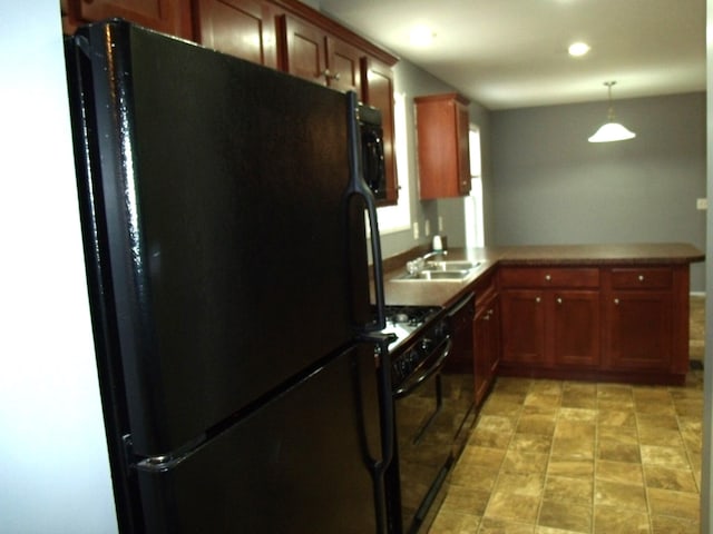 kitchen featuring kitchen peninsula, pendant lighting, sink, and black appliances