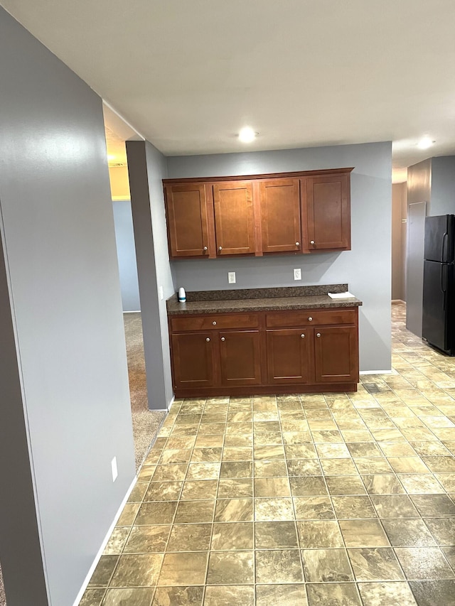 kitchen featuring black refrigerator and light colored carpet