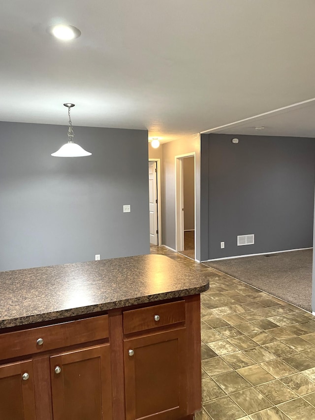 kitchen with pendant lighting and dark carpet