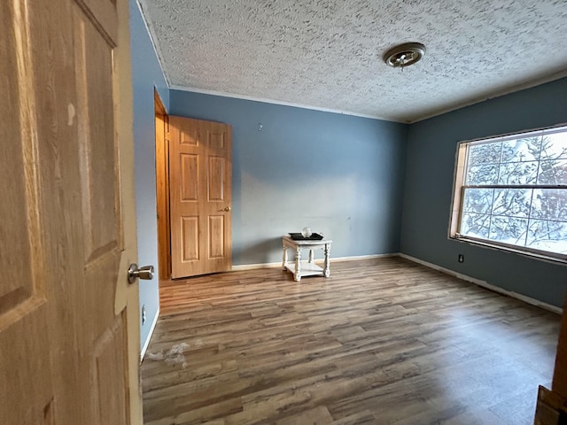 empty room with hardwood / wood-style floors and a textured ceiling