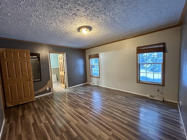 unfurnished bedroom featuring multiple windows, crown molding, dark wood-type flooring, and a textured ceiling