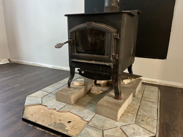 details with a wood stove and wood-type flooring