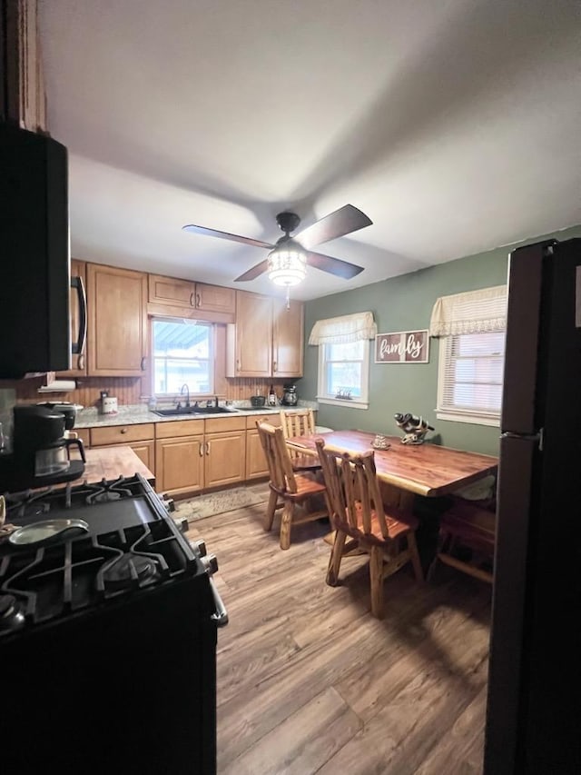 kitchen featuring refrigerator, sink, decorative backsplash, ceiling fan, and light hardwood / wood-style floors