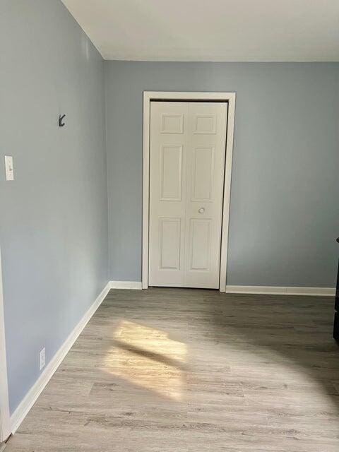 unfurnished bedroom with light hardwood / wood-style floors and a closet