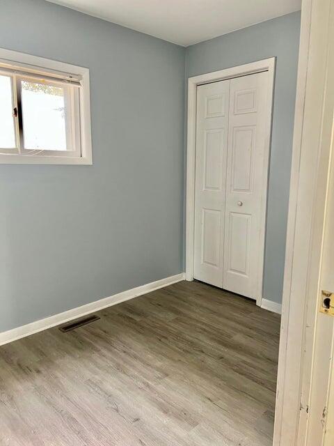 unfurnished bedroom with wood-type flooring and a closet