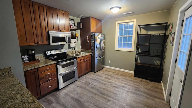 kitchen featuring light hardwood / wood-style flooring, a healthy amount of sunlight, and appliances with stainless steel finishes