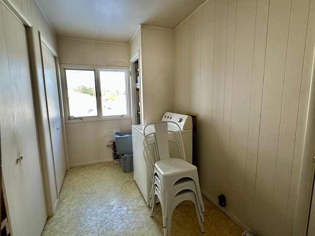 washroom with washer / dryer, wooden walls, and sink