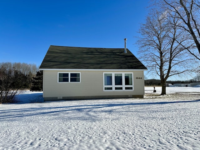 view of snow covered rear of property