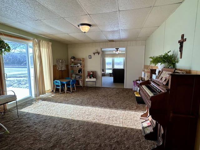 miscellaneous room featuring carpet flooring, a paneled ceiling, a healthy amount of sunlight, and ceiling fan