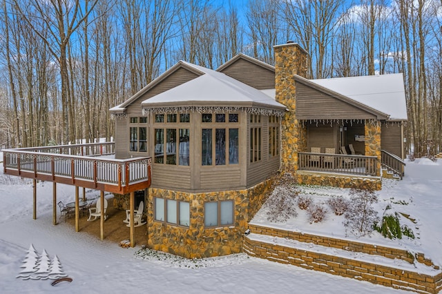 snow covered rear of property featuring a wooden deck