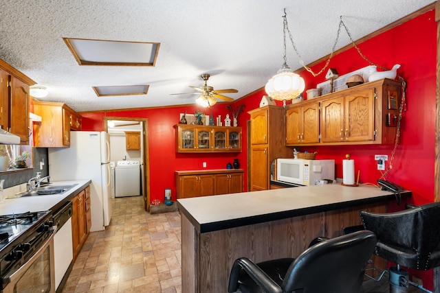 kitchen featuring kitchen peninsula, a kitchen breakfast bar, white appliances, a textured ceiling, and pendant lighting