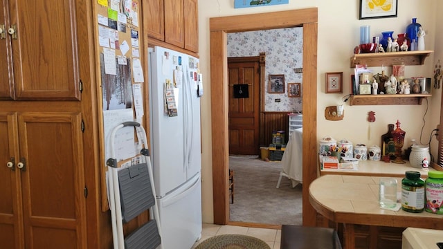 kitchen featuring light carpet, tile counters, and white refrigerator