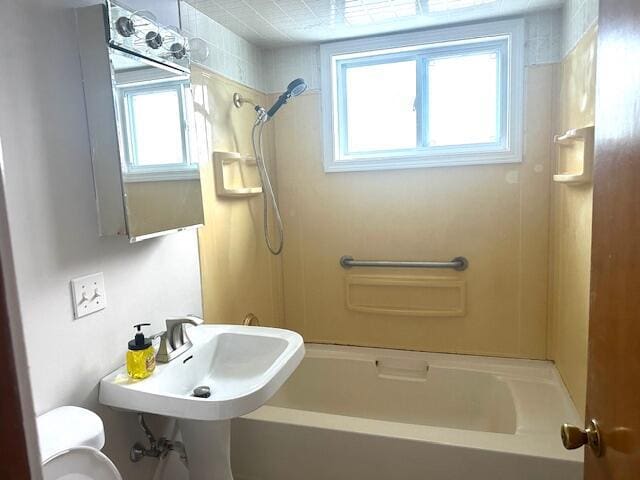 bathroom featuring toilet and washtub / shower combination