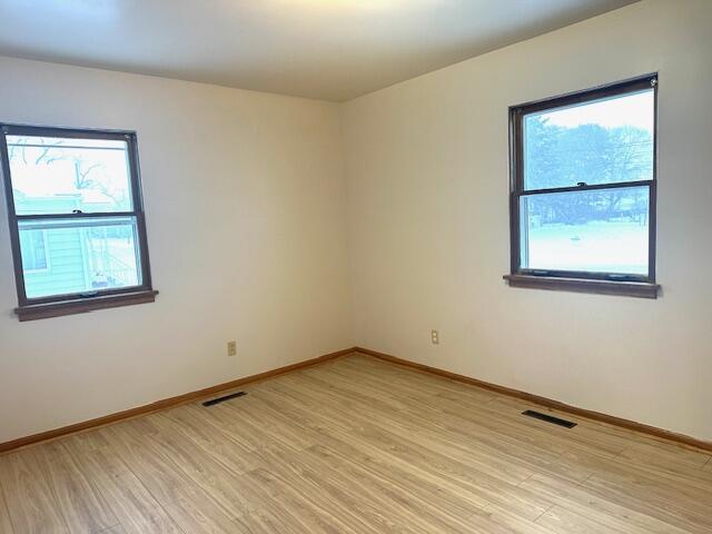 unfurnished room with light hardwood / wood-style floors and a wealth of natural light