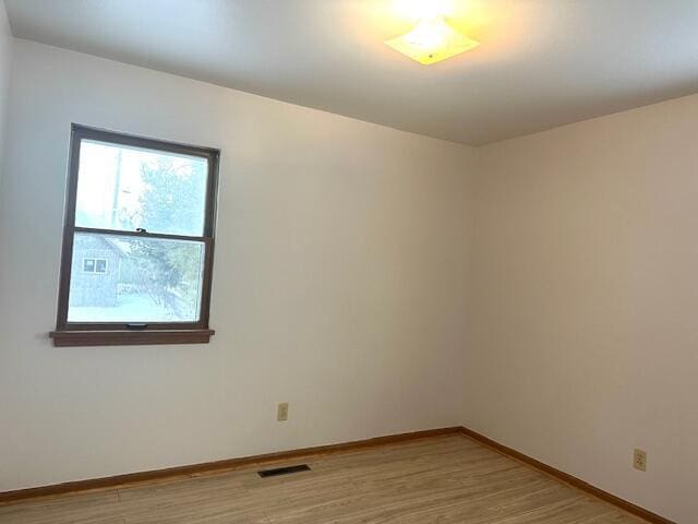 unfurnished room with light wood-type flooring