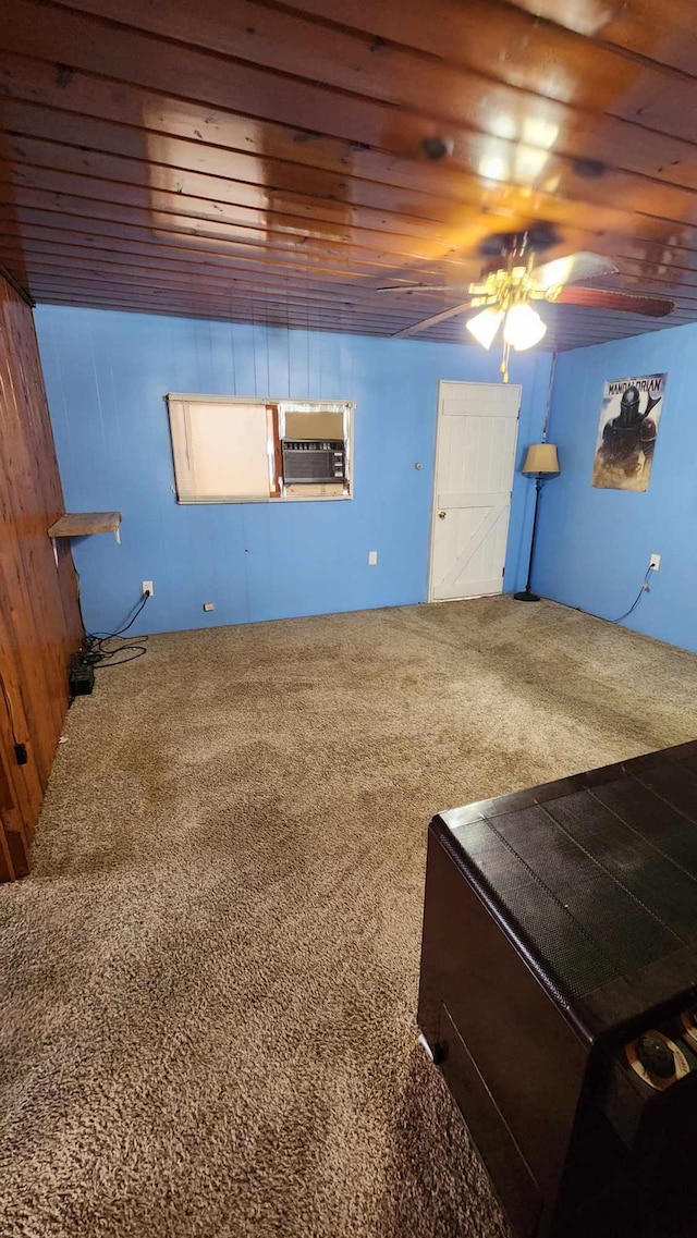 interior space featuring wood walls, ceiling fan, and wooden ceiling