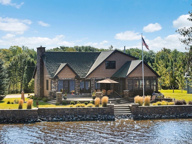 rear view of property featuring a patio area and a water view