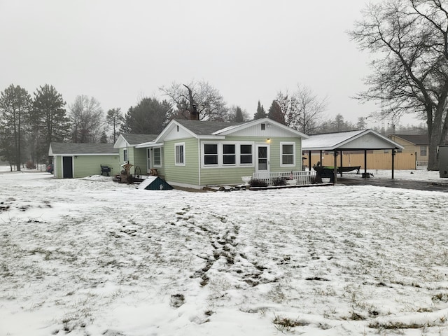 snow covered property featuring an outdoor structure