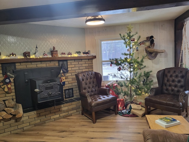 living room with a wood stove, wood walls, and wood-type flooring