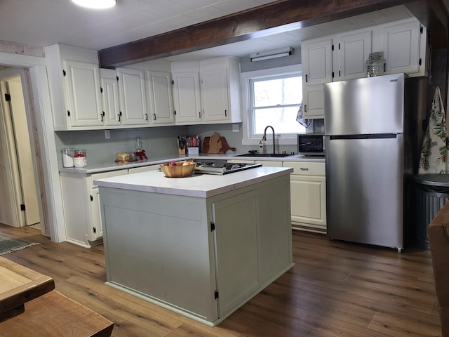 kitchen featuring hardwood / wood-style floors, a center island, white cabinetry, and appliances with stainless steel finishes